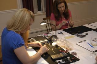 Ulrika G. GerthPaula Byers, purchasing representative, and Laurie Souza, president, of Gold to Green Parties, examine and price gold jewelry at a gold party in Newburyport last week.